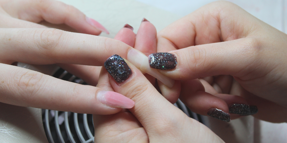 Glittery black and pink manicure with sparkling accents.