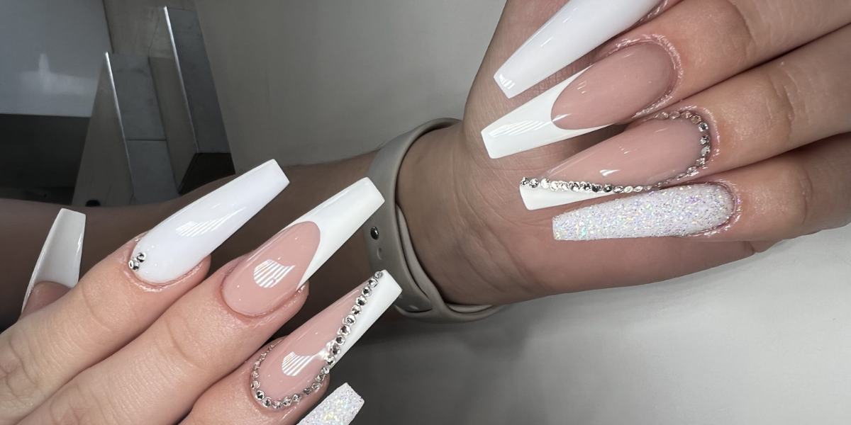 Elegant long coffin-shaped French tip nails with nude pink bases, white tips, glitter accents, and delicate rhinestone detailing.