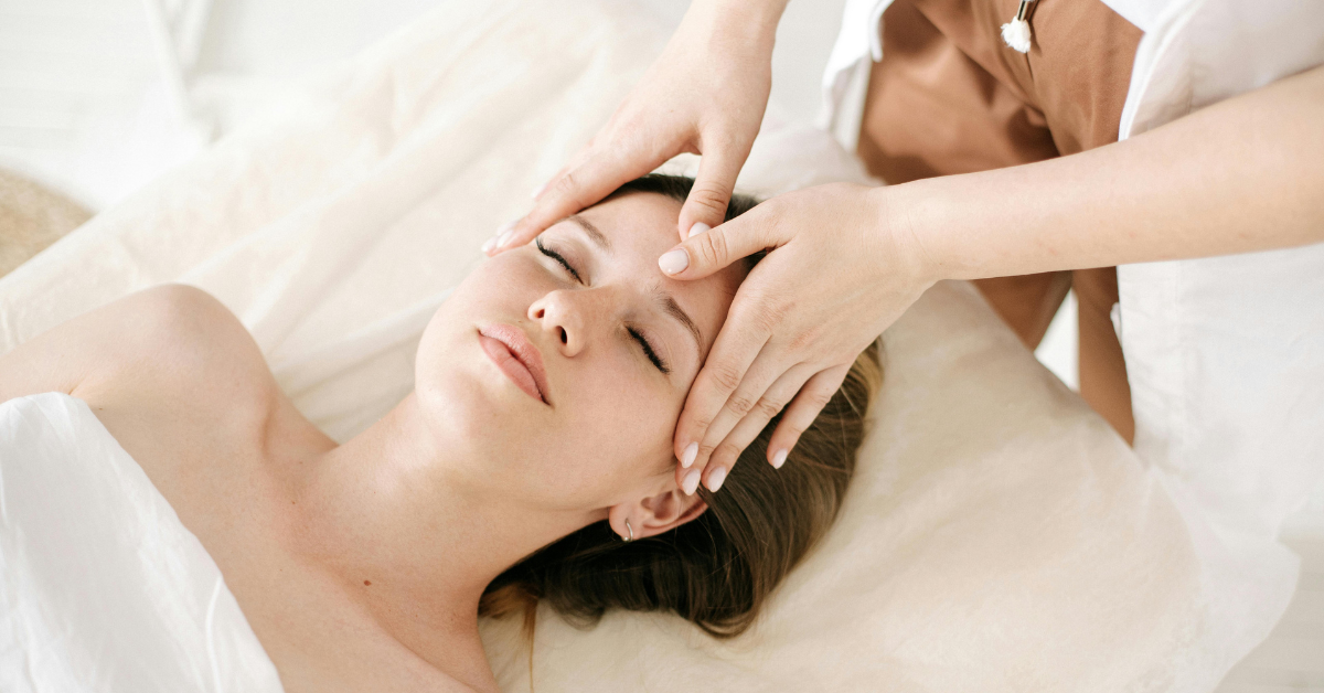 Woman relaxing during a soothing facial massage treatment at a spa.