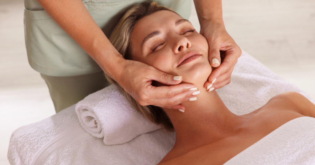 Relaxing facial massage treatment at a spa with a client lying comfortably on a treatment bed.