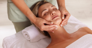 Relaxing facial massage treatment at a spa with a client lying comfortably on a treatment bed.