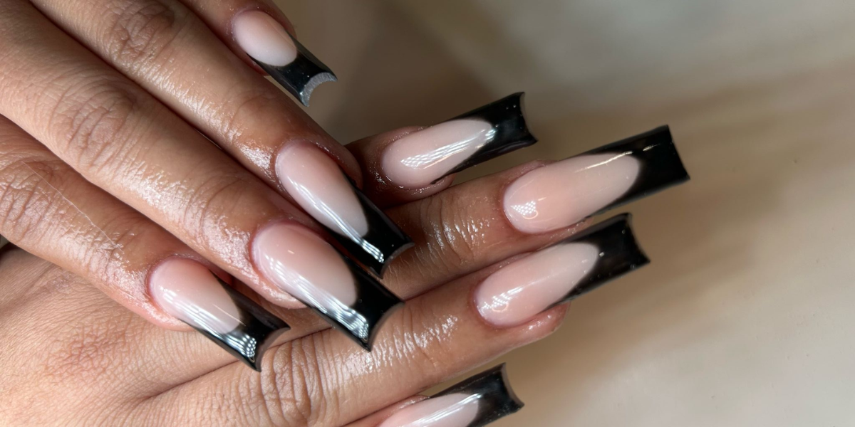 Black French-tip almond nails with glossy nude polish.