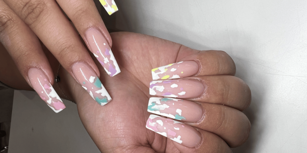 Pastel pink and white floral abstract nail art on long square nails.