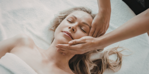 Relaxing facial massage treatment at a spa in Bellflower, with a client enjoying a soothing face massage on a treatment bed.