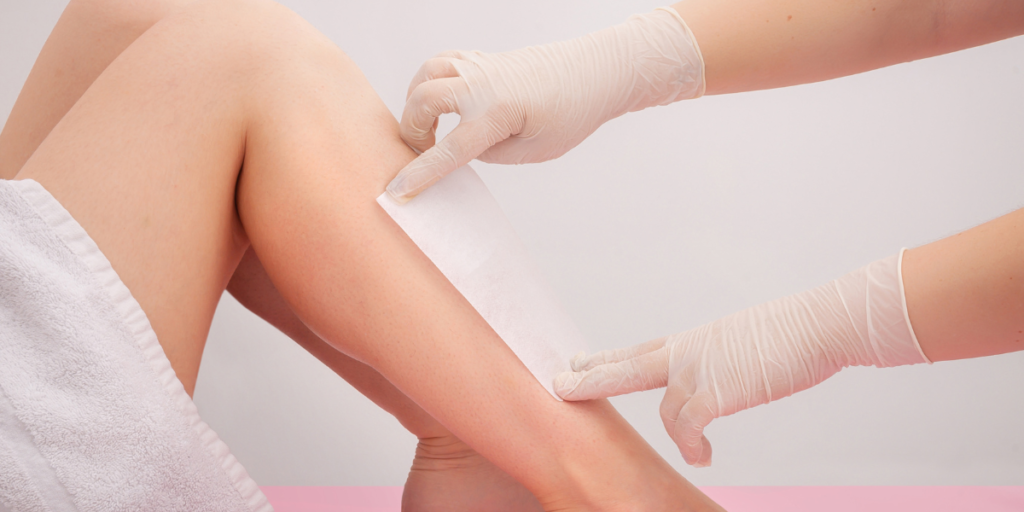 Waxing treatment on a client’s leg at a beauty salon.